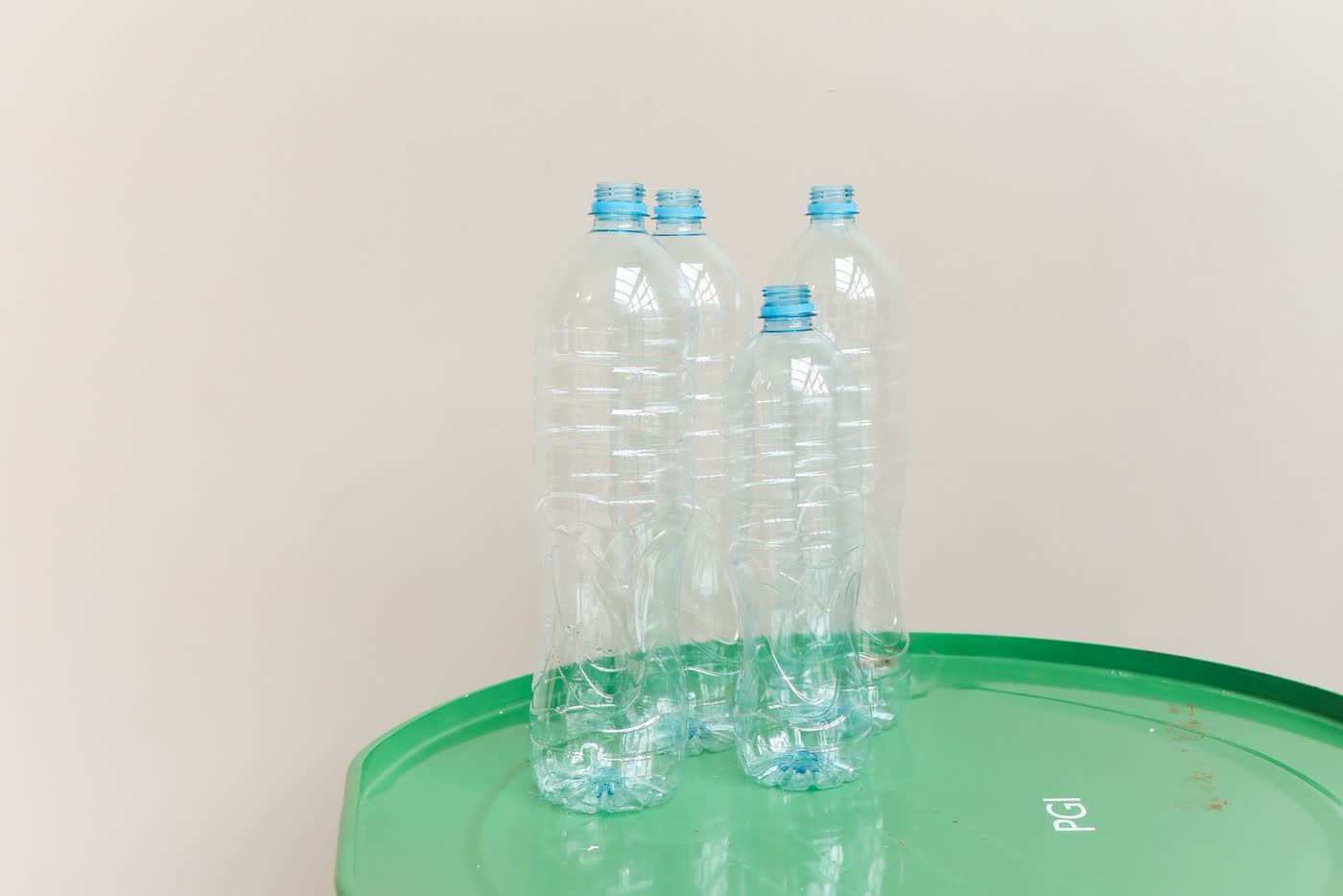 Clear PET bottles standing on a green drum