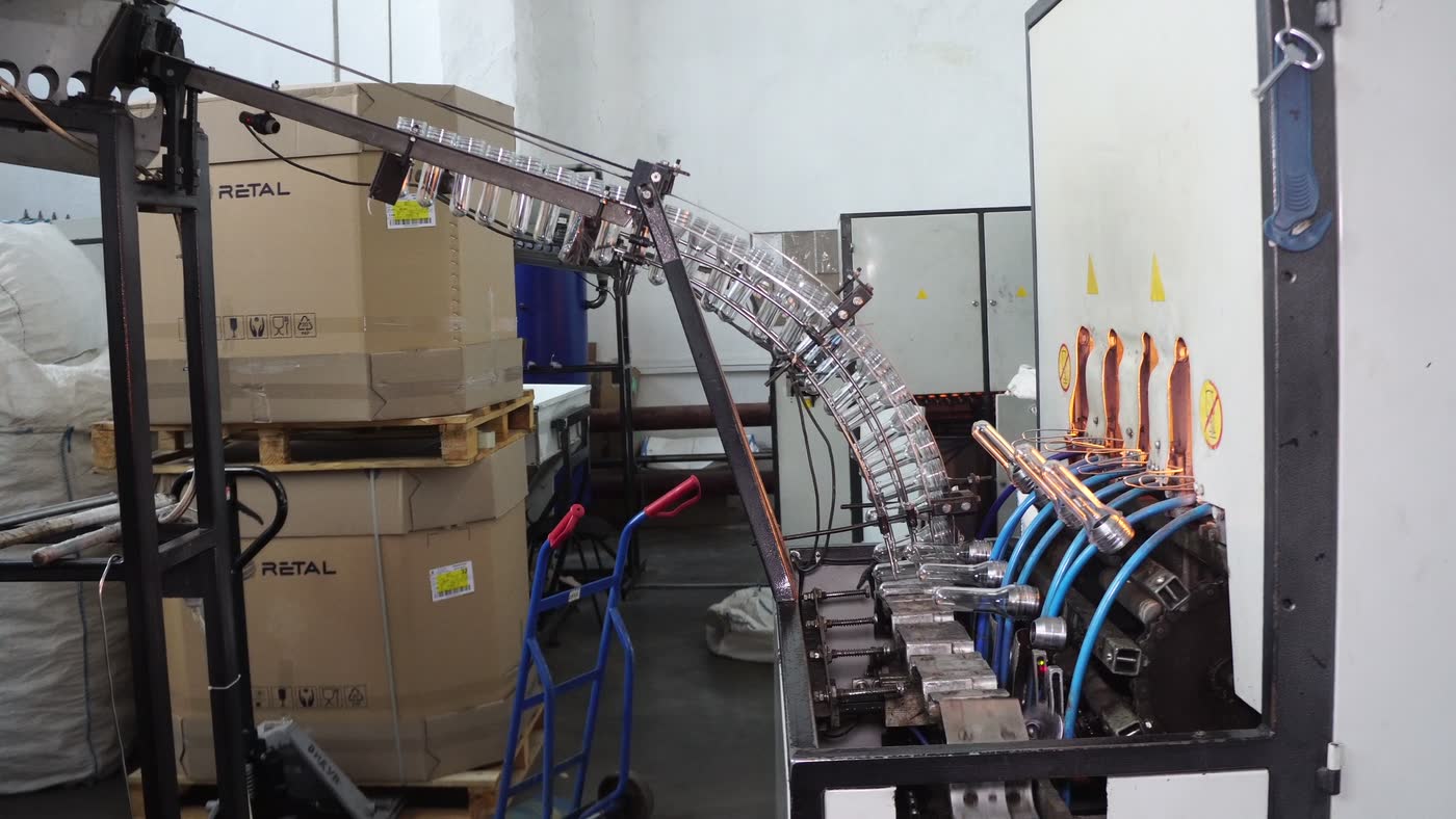 Preforms sliding down the feed rail into a blowing machine