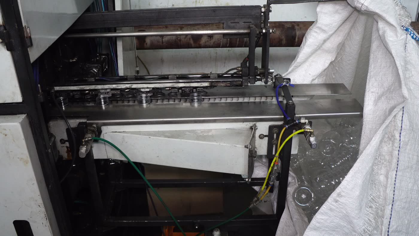 Freshly blown bottles leaving the blowing machine